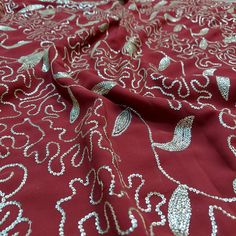 the fabric is red with silver designs on it