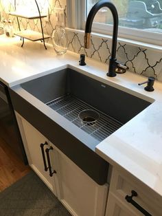 a kitchen sink sitting under a window next to a counter