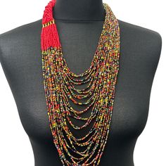 This beautiful beaded necklace features a long, red braided intricate beadwork. Its design reflects the traditional aesthetic of African fashion, with a touch of modern style. The hook closure secures the necklace in place, making it a convenient accessory to wear for any occasion. The vibrant red colour adds an eye-catching element to any outfit, while the beaded fringe adds a unique and elegant touch. This necklace is perfect for those who appreciate the beauty and cultural significance of African jewellery.  Colour - Red and Multicolours *Brass metal connectors  Total inner length - 22inches/56cm African Jewellery, Traditional Aesthetic, Beautiful Beaded Necklaces, Place Making, African Jewelry, Red Colour, Long Red, Beaded Fringe, Colour Red