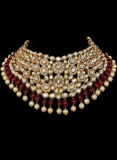 Ganga - Modern Bridal Set w/ Ruby Stones, Polki Jadau & Pearls Gorgeous delicate classic choker necklace with Kundan gemstones. Fit for any fashionista who appreciates the beauty of fine craftsmanship and design all in one stunning set! Contemporary bridal set with luxurious ruby drops and Polki Jadau. This bridal jewelry is further adorned with teardrop Kundan detailing. Luxurious pearl drops adorn this beautiful choker. This bridal set comes with dangling earrings with Ruby & teardrop Luxury Ruby Kundan Necklace For Reception, Luxury Gota Work Necklaces For Celebration, Luxury Ruby Chandbali Kundan Necklace, Jadau Three Piece Necklace, Elegant Kundan Choker Necklace For Ceremonial Occasion, Elegant Festive Choker, Elegant Kundan Choker Necklace With Tilla, Elegant Kundan Choker Necklace, Elegant Kundan Choker Necklace For Festivals