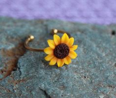 a sunflower ring sitting on top of a rock