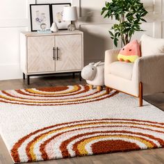 a living room with a rug, chair and potted plant