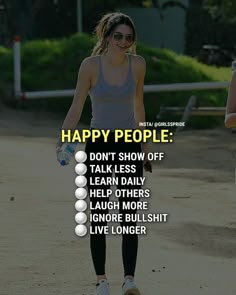 a woman walking down a dirt road with the words happy people on her chest and back