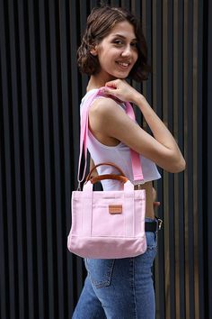 EXPRESS FAST SHIPPING FOR CHRISTMAS!  Check out our Pink Mini Canvas Tote--a practical and stylish sidekick for your everyday hustle. Boasting a single roomy space, a sturdy leather handle, and handy pockets inside and out, this bag is all about simplicity with a touch of smart design. The soft lining and easy snap closure keep things fuss-free. Plus, switch it up with the removable, adjustable shoulder strap--carry it your way, whether by hand, on your shoulder, or slung cross-body. Meet your new favorite, effortlessly cool companion! Details: Single compartment Leather handle Inner and outer pockets Lined Fabric Snap closure Removable and adjustable shoulder strap Size: Width: 24 cm (9,4 inches) Length: 20 cm (7,8 inches) Depth: 12 cm (4,7 inches) Strap: 110 cm (43 inches) You can visit Pink Large Capacity Handheld Satchel, Pink Handheld Satchel With Large Capacity, Pink Handheld Bag For On-the-go, Pink Handheld Satchel For School, Pink Shoulder Bag With Double Handle, Pink Bucket Bag For Daily Use, Pink Bucket Bag With Mobile Phone Pocket For Travel, Pink Bucket Bag With Mobile Phone Bag For Travel, Pink Travel Bucket Bag With Mobile Phone Pocket