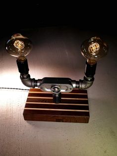 a wooden table with two light bulbs on it and a phone hooked up to the base