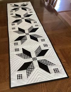 a black and white quilted table runner with an arrow design on the center piece