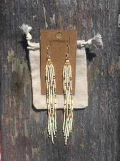 Wearable art: Long fringe earrings that are funky and unique!  Earrings are made with ivory, deep mustard yellow, turquoise, maroon, and black beads, strong synthetic thread, and light-weight sterling silver hooks.  I take great care in making all of my products because I love creating and wearing art.  These earrings are hand-stitched by myself, bead for bead, so each pair might have slight variations.  All shipping materials and packaging is made from recycled materials. Draw string bag is made from recycled tea bags and is included with every pair of earrings. Bead Weave Earrings, Cherokee Beaded Earrings, Turquoise Seed Bead Earrings, Handmade White Heishi Beads Earrings, Handmade Artisan Beaded Earrings, Artisan Beaded Fringe Earrings For Jewelry Making, Handmade Hippie Dangle Earrings, Handmade Heishi Beads Earrings For Festivals, Artisan Handmade Beaded Dangle Earrings