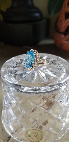 "D E S C R I P T I O N: 14kt Gold Blue Topaz Contemporary Ring; Large Oval Stone This wonderful piece of estate jewelry consists of a authentic large oval blue topaz stone set into a contemporary 14kt gold setting. It's in nice condition with very little signs of use. The large oval topaz is clear and faceted perfectly pick up the light and give a brilliant sparkle. This ring makes a statement and will definitely not disappoint. Beautiful!! Comes wrapped in the small Lenox crystal bowl pictured. Vintage Oval Topaz Ring With Polished Finish, Blue Oval Topaz Ring In 14k Gold, Oval Blue Topaz Ring In 14k Gold, Oval Topaz Ring For Formal Occasions, Formal Oval Topaz Ring With Polished Finish, Fine Jewelry Oval Blue Topaz Ring, Oval Blue Topaz Ring In Fine Jewelry Style, Oval Blue Topaz Ring Fine Jewelry, Formal Oval Topaz Ring