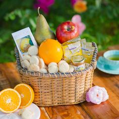 a basket filled with fruit sitting on top of a wooden table next to an orange slice