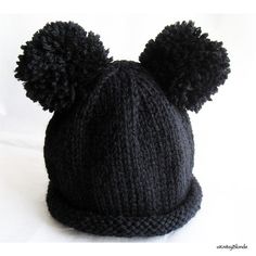 a black knitted hat with two pom - poms on the top and bottom