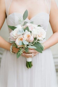 a bride holding a bouquet of flowers in her hands