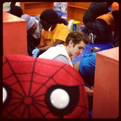 a group of young men sitting next to each other in front of desks with stuffed animals on them