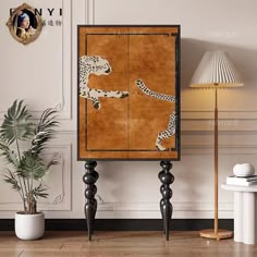 a wooden cabinet with two cheetah on it in a living room next to a potted plant