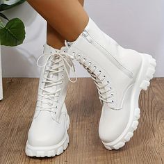 a close up of a person wearing white boots