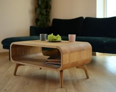 a coffee table sitting on top of a hard wood floor next to a black couch