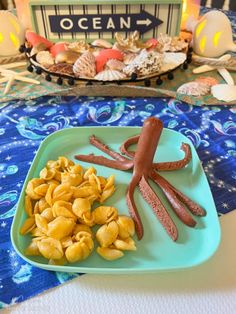 a blue plate topped with food next to an octopus shaped candy bar on top of a table