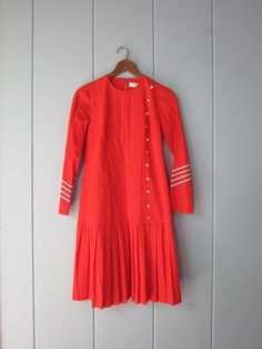 Lovely 60s nautical inspired red drop waist dress with a pleated mini skirt. This cute dress has white striped details on the sleeves and white faux button details in front. Perfect for Fall.  Tag Size: 11 Best Fits: Women's XS shoulders: 14" | bust: 36" | length: 37" | waist: 36"  Material: feels like a poly, cotton, linen Condition: Super nice, a few tiny marks at the bottom of skirt, as shown. Visit our SISTER SHOP: www.etsy.com/shop/dirtybirdiesvintage (if you buy from both we'll combine shipping for you - just ask!) *All items are preloved + may show natural light signs of wear. Larger flaws will be noted. Mini Rock, Trendy Christmas Outfits, Drop Waist Dress, Iowa City, Dropwaist Dress, Pleated Mini Skirt, Shirtdress, Cute Dress, Waist Dress