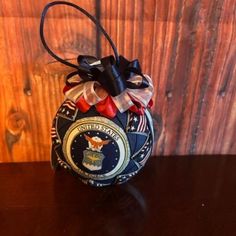 an air force ball ornament on a wooden table with a ribbon tied around it