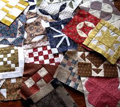 a pile of quilts sitting on top of a wooden table