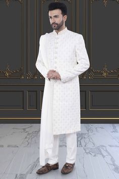 Elevate your wedding look with our Mens Sherwani- M42-S130. Made with quality fabric and intricate designs, this groom sherwani comes with a dupatta for added elegance. Expertly crafted for a perfect fit, this sherwani will make you stand out on your special day. Bollywood Sherwani With Intricate Embroidery For Groom, White Naqshi Salwar Kameez For Reception, Elegant Nehru Jacket With Dupatta For Reception, Fitted Sherwani With Chikankari Embroidery For Groom, Fitted Chikankari Embroidery Sherwani For Groom, White Nehru Jacket With Dupatta For Eid, Elegant Churidar With Dupatta For Ceremonial Occasions, Elegant Ceremonial Churidar With Dupatta, White Fitted Jamawar Bandhgala