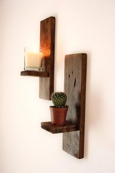 two wooden shelves holding candles and a potted plant