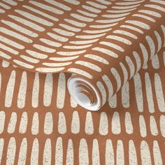 an orange and white wallpaper with small circles on the ground, in front of a brown background