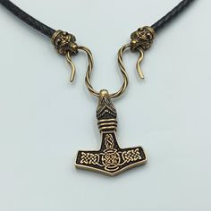 This Mjolnir pendant is reenactment of archeological find based on artifacts from 10th century Denmark. The Hammer of Thor is made from Italian bronze, this is high quality replica. The necklace is made from leather cord. The Thors Hammer in Viking age was used as amulet for men and women. If you like Norse or Nordic jewelry - you`ll like this item. The item shipped in wooden jewelty box, so it`s perfect mens gifts option. The are wolf, raven, dragon, goat, bear necklace variations. Thors hammer Medieval Pendant Collectible Jewelry, Medieval Pendant Jewelry For Collectors, Medieval Collectible Pendant Jewelry, Gold Viking Style Necklace For Gift, Bronze Viking Jewelry Collectible, Viking Style Bronze Jewelry Gift, Viking Style Handmade Gold Jewelry, Handmade Viking Gold Jewelry, Handmade Viking Style Gold Jewelry