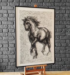 a framed drawing of a horse on a wooden easel in front of a brick wall