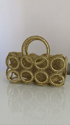 Made of;   metallic gold paper rope 28cm width  15cm hight  13cm diameter holders on sides Compatible with any kind of usage Can be cleaned only with dry cleaning, cleanings other than dry cleaning might cause discolouration. Fashionable handmade purse for your style.  Can be cleaned only with dry cleaning, cleanings other than dry cleaning might cause discolouration. Elegant Gold Straw Bag With Gold-tone Hardware, Luxury Gold Straw Bag, Chic Gold Straw Bag With Braided Handles, Luxury Gold Straw Bag With Braided Handles, Gold Straw Bag With Gold-tone Hardware For Everyday, Chic Gold Straw Bag For Evening, Chic Gold Rectangular Straw Bag, Chic Gold Straw Evening Bag, Handmade Gold Straw Bag