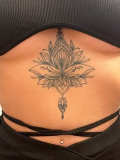 a woman's stomach with a lotus tattoo on her belly and the bottom part of her lower back