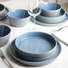 the table is set with blue dishes and silverware