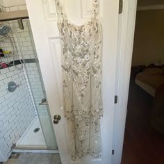 a white dress hanging on a door in a bathroom