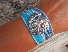 a close up of a person's arm wearing a bracelet with an elephant on it