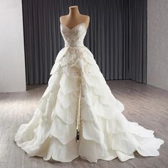 a wedding dress on display in front of a curtain