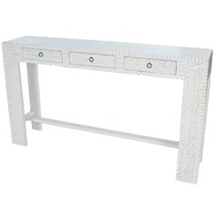 a white console table with two drawers on one side and an ornate design on the other