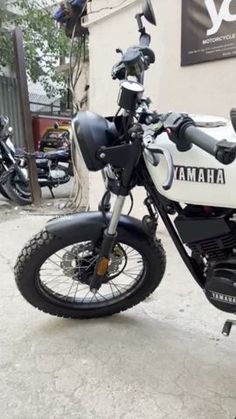 a white and black motorcycle parked in front of a building