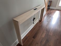 an empty room with wood flooring and a wall mounted shelf on the side of it