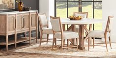 a dining room table with four chairs and a cabinet in front of it that has a painting on the wall