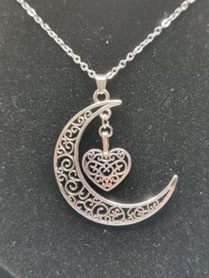 This customizable moon pendant necklace comes in four different colors: white, silver, bronze, and gold. The smaller charm spot offers a variety of options including an antique-style heart that matches the design of the moon in silver, a white moon with a pearl, a bronze heart with leaves, and golden moons with options such as white and pink flowers or small globes with decorative crushed glass in red, purple, and blue. Create a unique and personalized piece by selecting your preferred combination of base color and charm. Message me if you have any questions or special requests. Silver Moon Charm Necklace For Gift, Silver Alloy Heart Pendant Charm Necklace, Heart Shaped Silver Alloy Charm Necklace, Symbolic Silver Alloy Jewelry, Elegant Silver Charm Necklace With Moon Charm, Silver Heart-shaped Alloy Necklace, Silver Charm Necklace In Alloy, Silver Heart Pendant Necklace In Alloy, Moon Shaped Sterling Silver Jewelry For Mother's Day