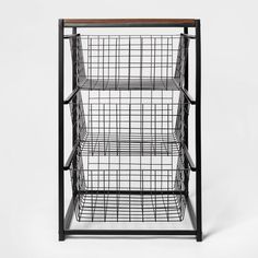 a black metal shelf with wire baskets on top