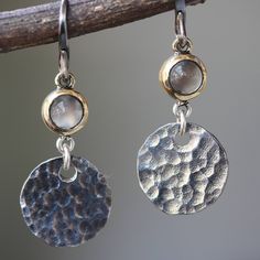 Round cabochon moonstone earrings in brass bezel setting with circle silver hammer textured and oxidized sterling silver hooks(FBA) Earrings measure: 15 mm W x 40 mm H ABOUT All items are hand crafted by me, Sirilak Samanasak in Chiang Mai, Thailand. Each piece is one of a kind and the item pictured is the exact item that will ship. Every gemstone is hand selected for its quality and beauty and are hand set into settings and final jewelry pieces. JEWELRY CARE Most jewelry in my shop is sterling Luxury Hammered Round Jewelry, Luxury Silver Cabochon Earrings, Tarnished Jewelry, Chiang Mai Thailand, Moonstone Earrings, Hammered Silver, Chiang Mai, Sterling Silver Bands, Bezel Setting