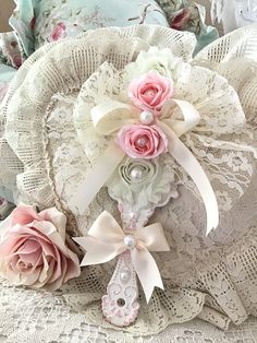 a close up of a decorative object on a lace doily with pink roses and pearls