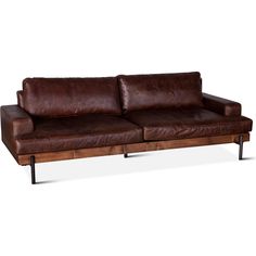 a brown leather couch sitting on top of a wooden table