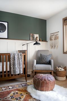 a baby's room with a chair, crib and rugs on the floor