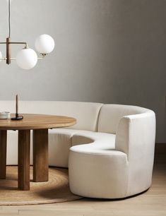 a living room with a round table and two chairs next to a white sectional couch