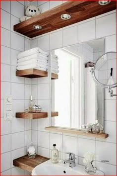 a bathroom with white tile and wooden shelves on the wall, along with a sink