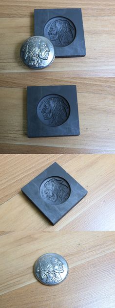 three metal coasters sitting on top of a wooden table next to two silver plates