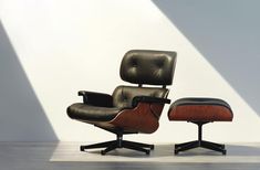 an eames lounge chair and ottoman with the sun shining on it's back