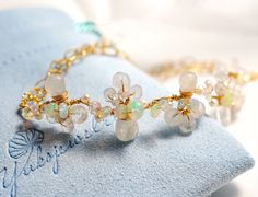 "The bangle is designed to represent lovely white flowers blooming on a vine.  Perfect for boho casual wedding or any of your special occasions.   ●  Material   14K gold filled ●  Gemstone   Rainbow moonstone and Fresh water pearl, Ethiopian Opal ●  Size  Flower vine  3.5\" (9cm) in length ●  Chain Patterned flat cable chain ●  Closure   Lobster claw ●  Come in a pouch and gift box ● Made to Order Processing time is 5 - 10 business days before shipping. If you need item(s) to ship within a tight Wire Wrapped Bangle Jewelry For Wedding, Bohemian Gemstone Bracelets For Wedding, Bohemian Wedding Bracelets With Gemstones, Bohemian Wedding Gemstone Bracelets, Wedding Bangle Bracelets With Natural Stones, Hand Wrapped Bangle Jewelry For Wedding, Wedding Bangle Bracelet With Natural Stones, Wedding Bangle Jewelry Hand Wrapped, Wedding Hand-wrapped Bangle Jewelry