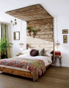 a bed sitting in a bedroom next to a wooden headboard and window sill